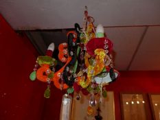 A contemporary designer three branch chandeliers clad in various fabrics and with cut glass lustres,