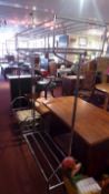 A pair of chromed two tier clothes hanging racks, with covers, raised on castors.