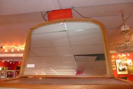 A pine overmantel mirror of domed outline.