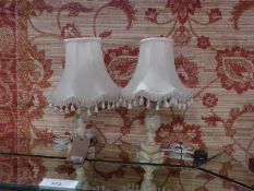 A pair of alabaster urn form table lamps with silk shades.