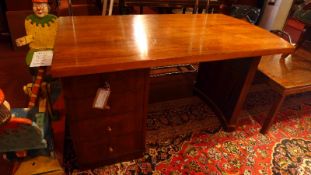 A 1960s rosewood desk having four drawers and raised on shaped supports.