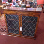 A Regency rosewood bookcase fitted frieze drawer above pair of leaded glazed panel doors enclosing