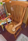 An elm and pine grandfather chair with solid seat and raised on turned supports.