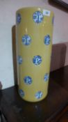 A Chinese porcelain stickstand of a cylindrical form and glazed yellow.