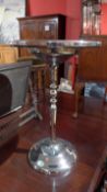 A nickel plated oak occasional table with circular top.