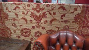 A Ziegler style carpet the beige ground having repeating foliate motifs within broad border.