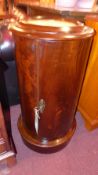 A Victorian mahogany cylindrical form pot cupboard with inset marble top and single panel door on