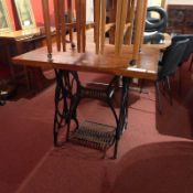 An oak side table, the rectangular top raised on Singer sewing machine supports.