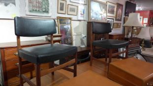 A set of seven retro mid 20th century rosewood dining chairs upholstered in black faux leather.