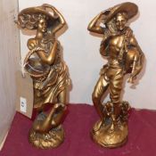 A pair of Continental style gilded figures of a male and female farm workers.
