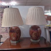 A pair of hexagonal table lamps having a mottled finish and incised gilt decoration raised on