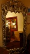 A Chippendale style slivered and carved wall mirror with ornate pierced and scrolling detail