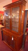 A late Victorian carved walnut library bookcase fitted pair of glazed panel doors above two drawers