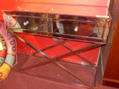 A modern mirrored glass side table fitted two drawers and raised on chromed X frame supports.