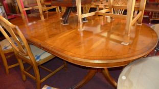A Regency style line inlaid twin pillar dining table with one extra leaf.