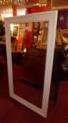 A white painted wall mirror the rectangular bevelled plate within a moulded frame.