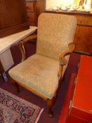 A Georgian style walnut armchair upholstered in gold patterned fabric and raised on cabriole pad