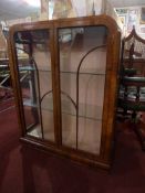 An Art Deco walnut display cabinet fitted pair of glazed panel doors enclosing glass shelves.