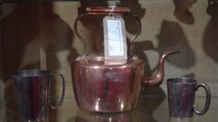 A copper kettle together with two silver plated mugs.