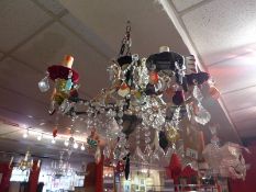A vintage six branch chandelier clad in various fabrics and having glass lustres.