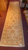 An Agra design runner, the beige ground having floral motifs.