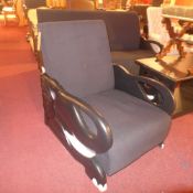 A pair of contemporary armchairs upholstered in black fabric and the matching side table raised on