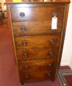 A 20th century oak tall chest fitted six drawers with ring handles and raised on turned feet.