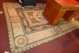 An Art Deco design woollen rug the green fields with flowerhead decoration.