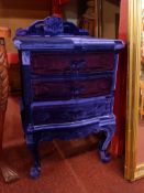 A Queen Anne style bedside chest fitted three drawers and clad in purple patchwork velour.