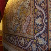 A Persian rug the beige field having central medallion and extensive foliate motifs in a triple