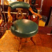 A Victorian oak chest chair upholstered in green leather and raised on swivel supports.