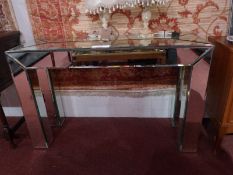 A contemporary designer mirrored glass console / hall table with bevelled edges,