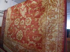 A Ziegler style rug the rouge field with repeating floral motifs in a triple border.