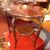 An Edwardian mahogany two tier occasional table raised on slender cabriole supports.