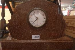 An Art Deco rouge marble mantel clock with fanned ends on plinth base.