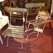 A pair of vintage wrought iron and painted teak garden chairs (af) and a matching umbrella stand