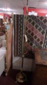 A Victorian brass telescopic standard lamp with acanthus wreath detail and lion paw feet.