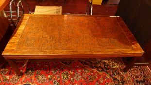 A contemporary designer rosewood and embossed copper low / coffee table raised on square tapering
