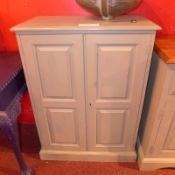 A grey painted pine side cabinet fitted pair of panelled doors on plinth base.