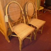 A pair of bamboo and rattan side chairs raised on stretchered supports.