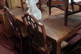A vintage oak dining table, the rectangular top raised on square tapering supports.