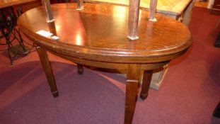 An oak occasional table, the oval top raised on square tapering supports.