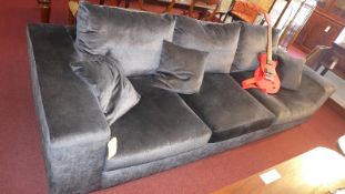 A contemporary designer four seater sofa upholstered in grey velour and raised on block supports,