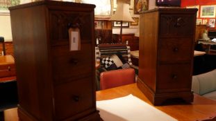 A pair of 1930's carved oak pedestal chests fitted three drawers with knob handles on bracket