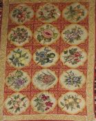 A late 19th Century Victorian English needlepoint rug, the repeating fruit motifs on a scarlet
