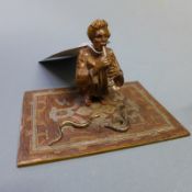 A Franz Bergman cold painted bronze figure group of a snake charmer and snakes on a Persian rug with