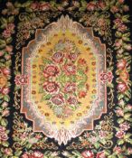 A antique Besarabian kilim, the central foliate medallion on a noire ground having corresponding