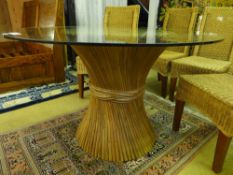 A contemporary designer breakfast dining table, the round glass top over spiralled wooden tambor