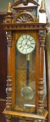 A 19th Century walnut Vienna regulator wall clock having enamelled dial surmounted by carved