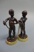 A pair of late 19th Century patinated bronze putti holding swords on onyx supports, both signed L